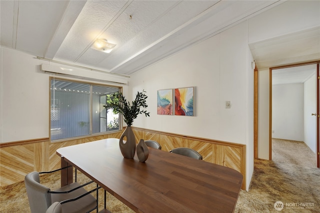 dining area featuring vaulted ceiling, carpet floors, and a textured ceiling