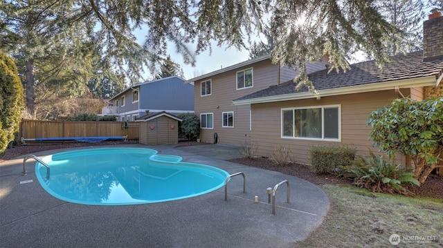 view of pool with a storage unit and a patio