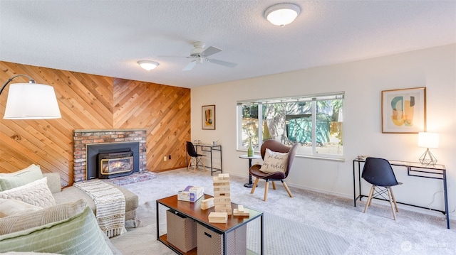 carpeted living room with ceiling fan, wooden walls, and a textured ceiling