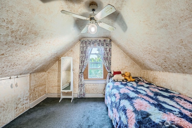 unfurnished bedroom with ceiling fan, vaulted ceiling, and dark colored carpet