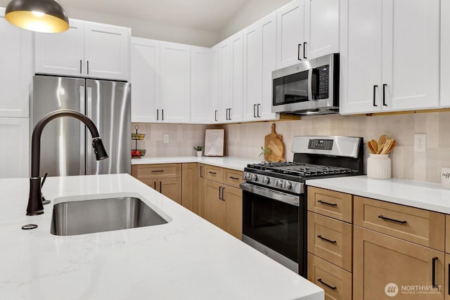 kitchen featuring white cabinetry, stainless steel appliances, sink, and decorative backsplash