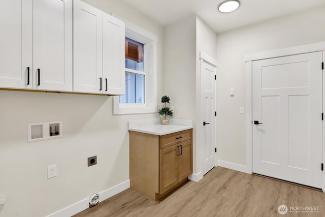 clothes washing area with cabinets, washer hookup, light wood-type flooring, and electric dryer hookup