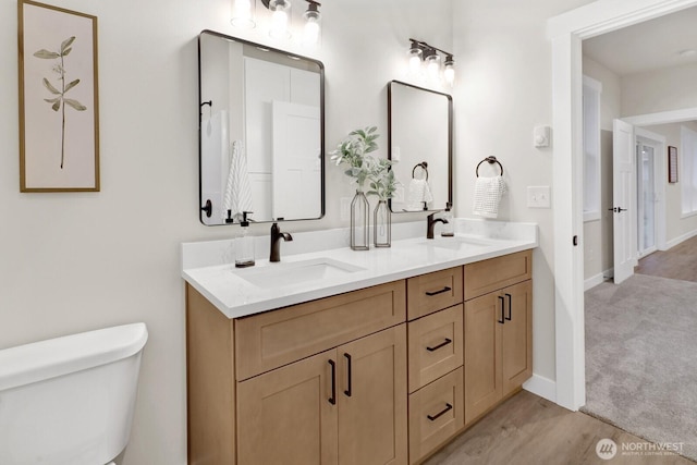 bathroom featuring vanity, hardwood / wood-style flooring, and toilet