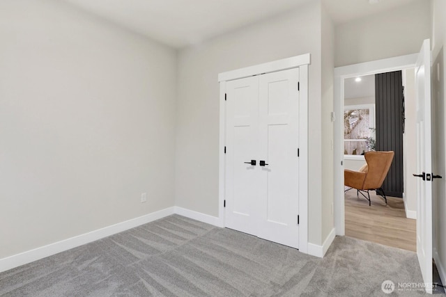 unfurnished bedroom with light carpet and a closet