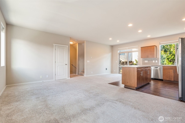 kitchen featuring tasteful backsplash, stainless steel appliances, a center island, and dark carpet