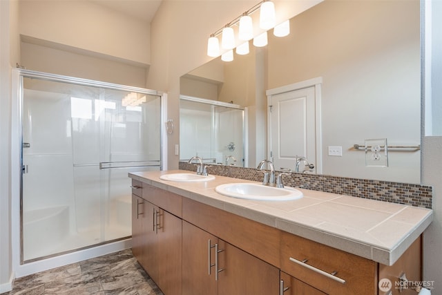 bathroom featuring walk in shower, vanity, and tasteful backsplash