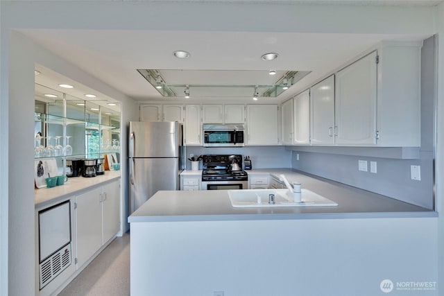 kitchen featuring white cabinetry, stainless steel appliances, and a peninsula