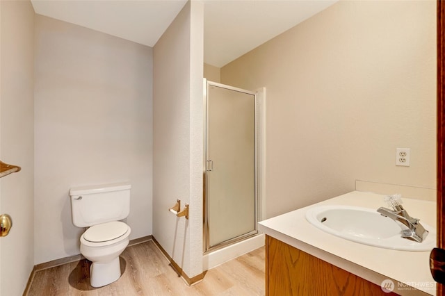 bathroom with toilet, vanity, wood-type flooring, and walk in shower