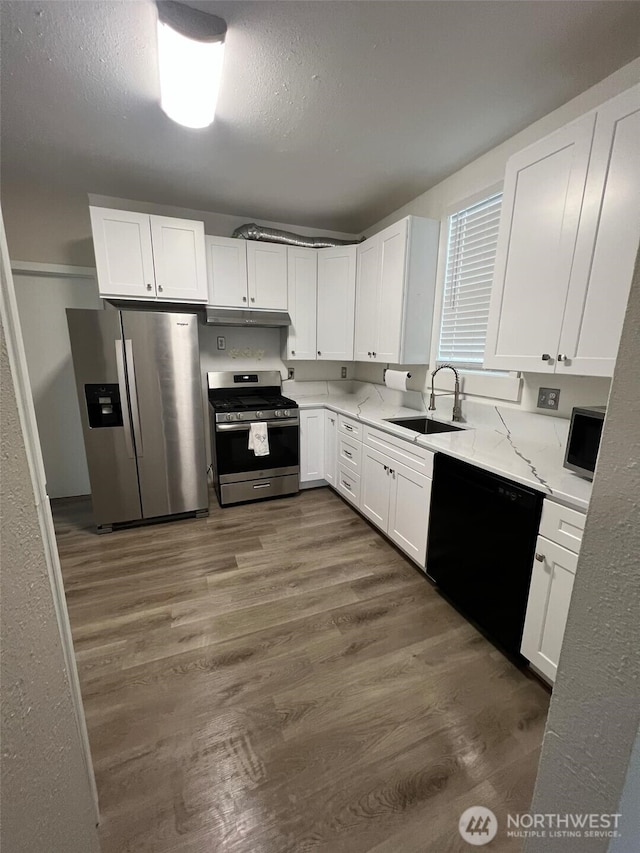 kitchen with white cabinetry, stainless steel appliances, and sink