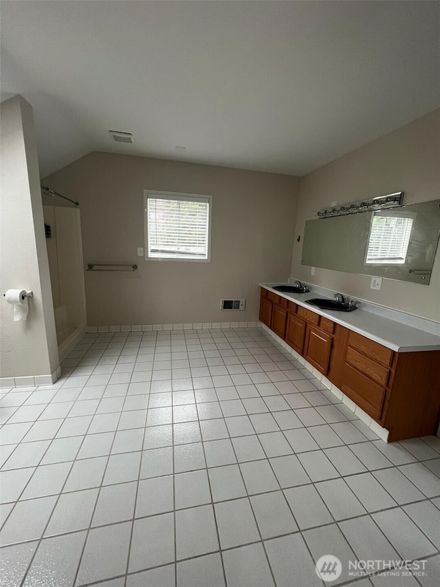 bathroom featuring vaulted ceiling, a shower, vanity, and tile patterned floors