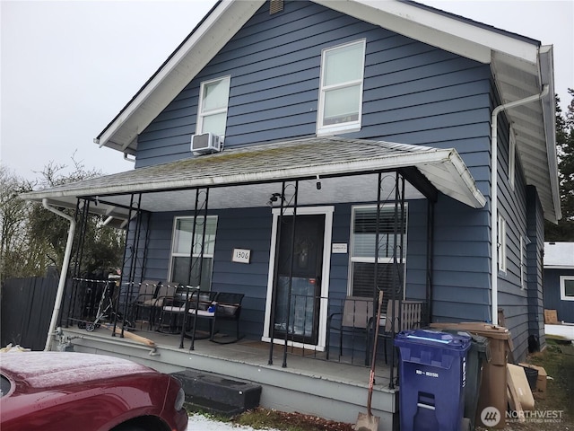 back of property with cooling unit and covered porch