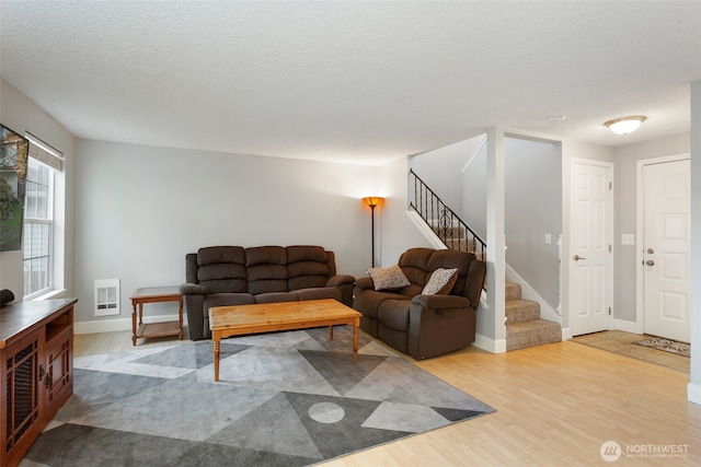 living room with light hardwood / wood-style flooring and a textured ceiling