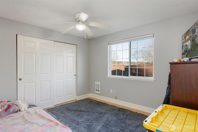 bedroom with ceiling fan, a closet, and a textured ceiling