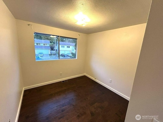 21405 124th Ave SE, Kent, WA 98031 - unfurnished room featuring visible vents, a textured ceiling, dark wood-type flooring, and baseboards