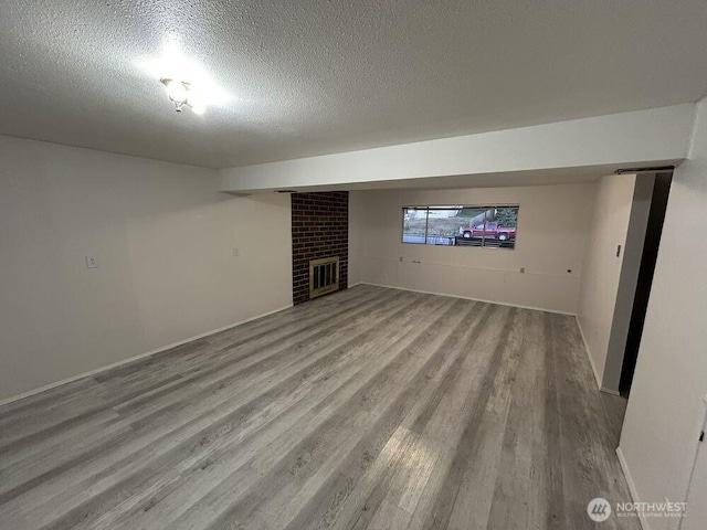 21405 124th Ave SE, Kent, WA 98031 - below grade area featuring baseboards, a textured ceiling, wood finished floors, and a fireplace