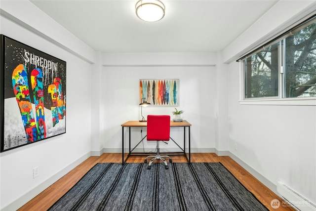 office featuring a baseboard heating unit and wood-type flooring