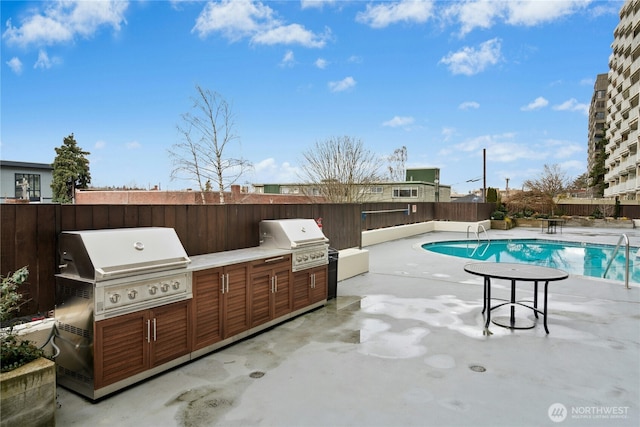 view of pool featuring a patio, area for grilling, and exterior kitchen