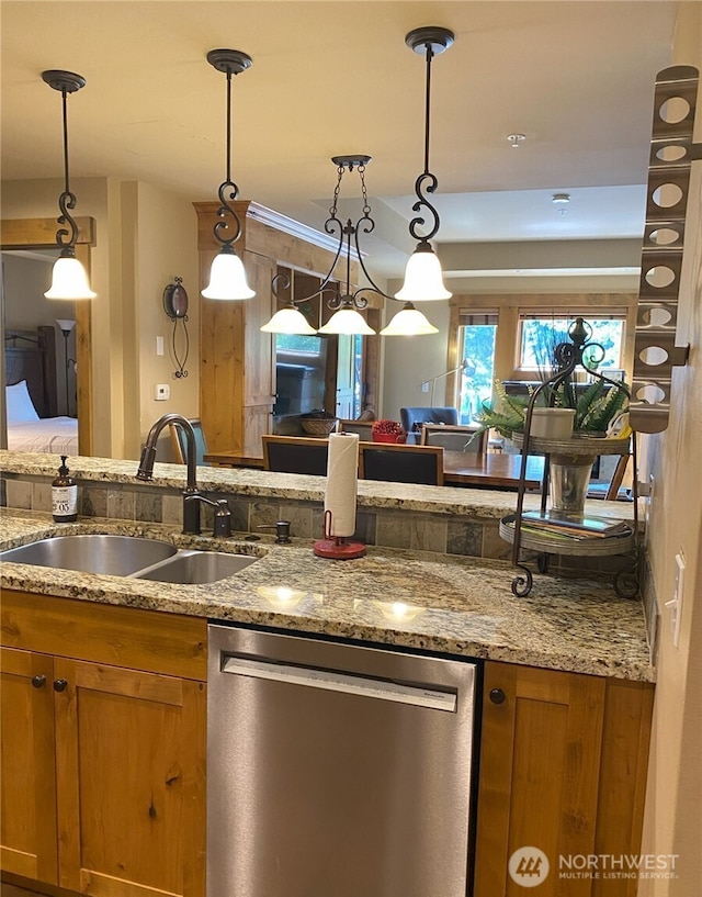 kitchen featuring pendant lighting, sink, light stone countertops, and dishwasher
