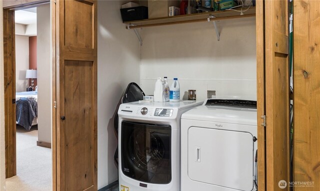 clothes washing area with light colored carpet and washing machine and clothes dryer