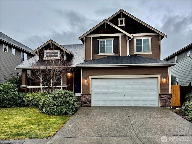 craftsman house with a garage and a front lawn