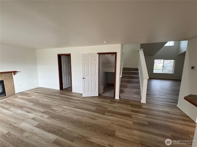 unfurnished living room featuring wood-type flooring and a fireplace