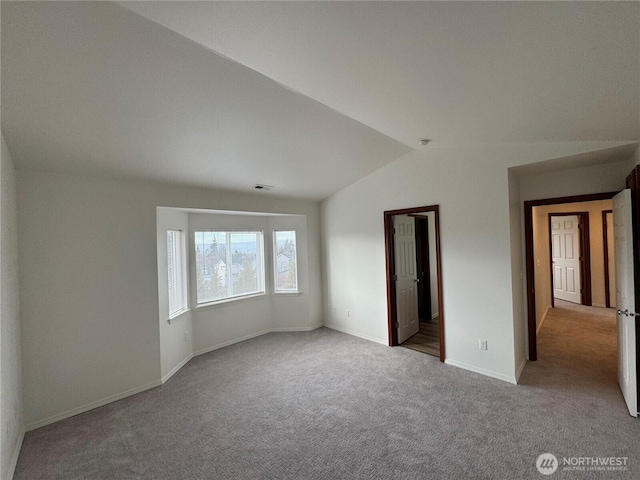 unfurnished bedroom featuring lofted ceiling and light carpet