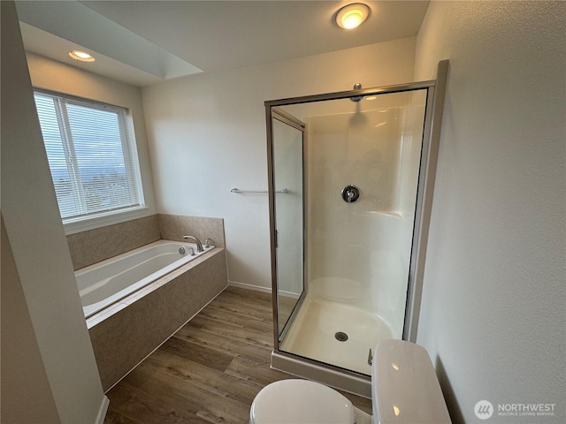 bathroom with hardwood / wood-style floors, shower with separate bathtub, and toilet