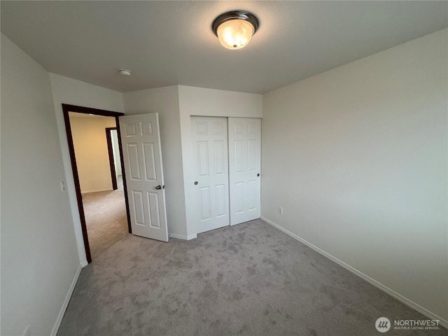 unfurnished bedroom featuring light colored carpet and a closet