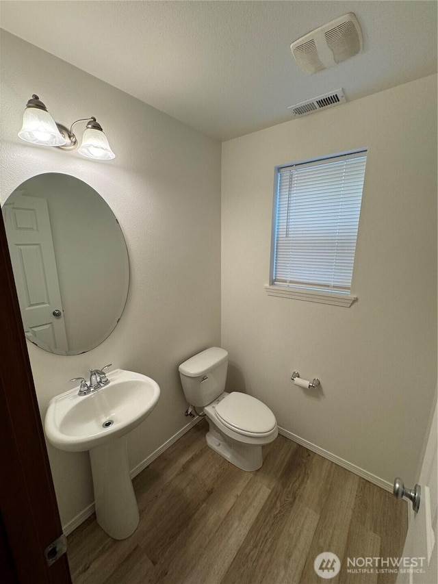 bathroom with wood-type flooring and toilet