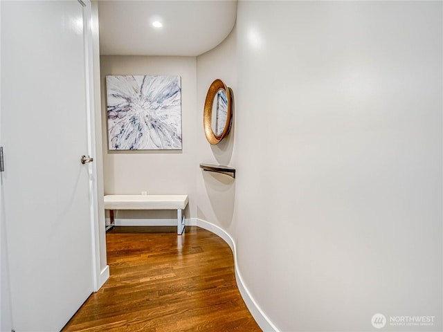 hallway with baseboards, wood finished floors, and recessed lighting