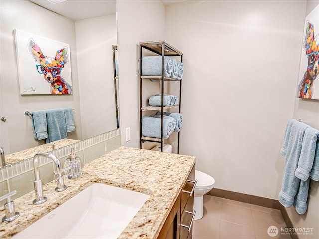 bathroom with tile patterned flooring, toilet, vanity, and baseboards