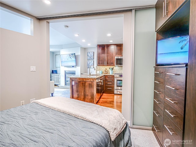 bedroom with a fireplace, a sink, and recessed lighting