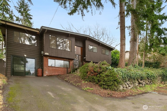 exterior space featuring aphalt driveway and brick siding