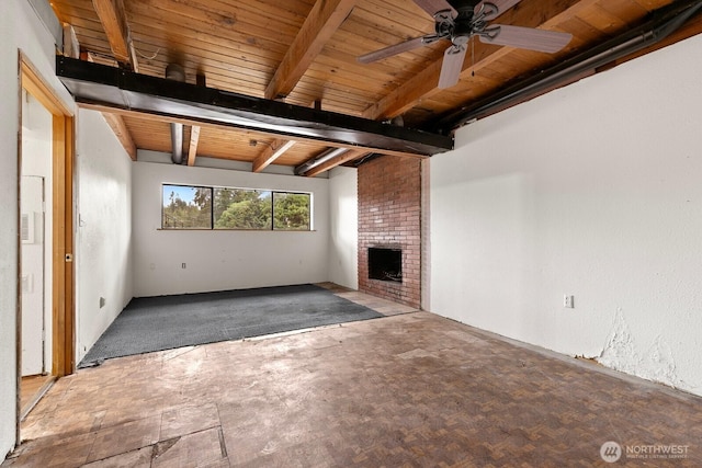 unfurnished living room featuring beam ceiling, a brick fireplace, wood ceiling, and ceiling fan