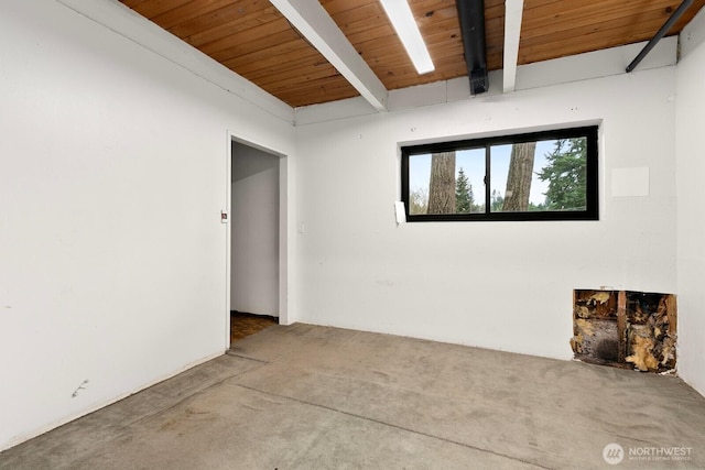 spare room featuring beamed ceiling and wood ceiling