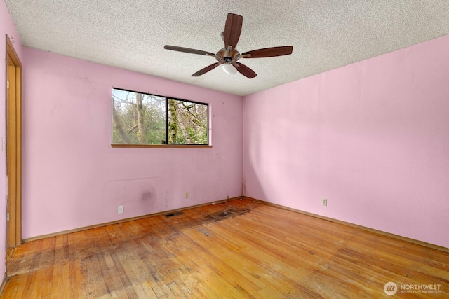 spare room with visible vents, a textured ceiling, ceiling fan, and hardwood / wood-style floors