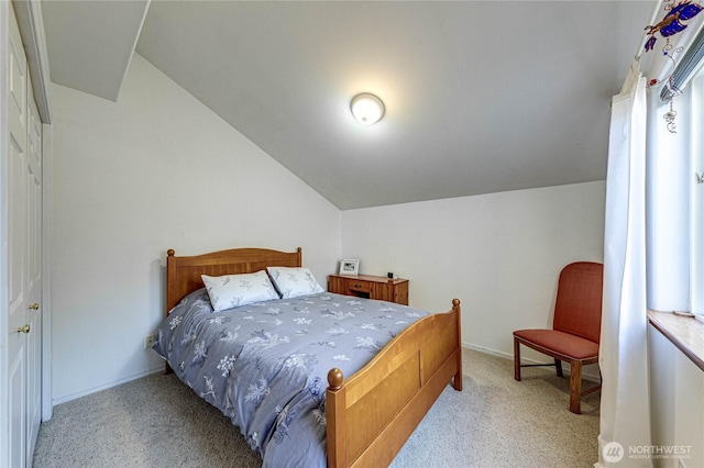 carpeted bedroom with vaulted ceiling and baseboards