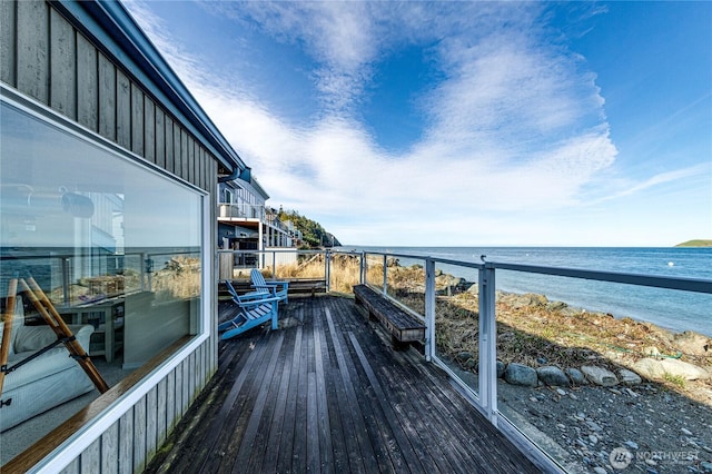 balcony with a water view and a view of the beach