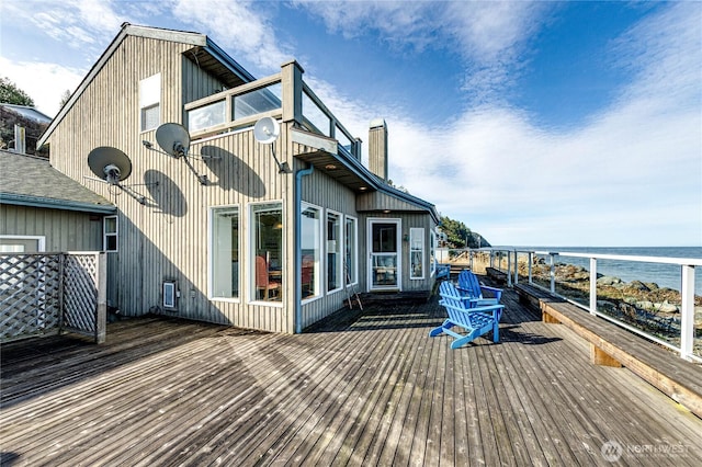 back of house with a chimney and a deck with water view