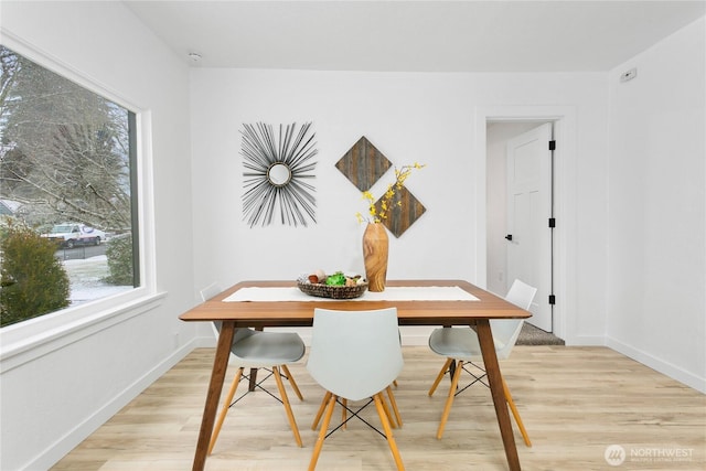 dining area featuring baseboards and light wood finished floors