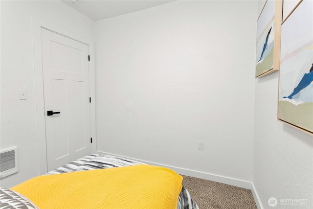 carpeted bedroom with heating unit and baseboards