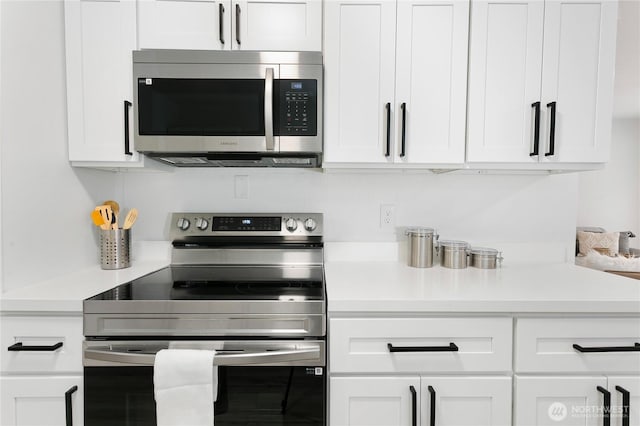 kitchen with white cabinetry, stainless steel appliances, and light countertops