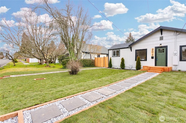 view of front of property with fence and a front lawn