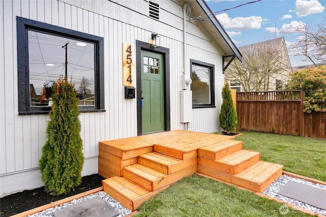 entrance to property with fence and a lawn