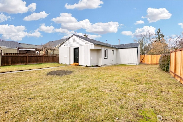 back of house featuring a fenced backyard and a lawn