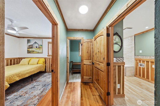 hallway featuring ornamental molding and light hardwood / wood-style flooring