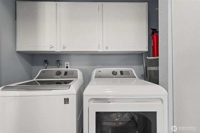 washroom featuring cabinets and separate washer and dryer