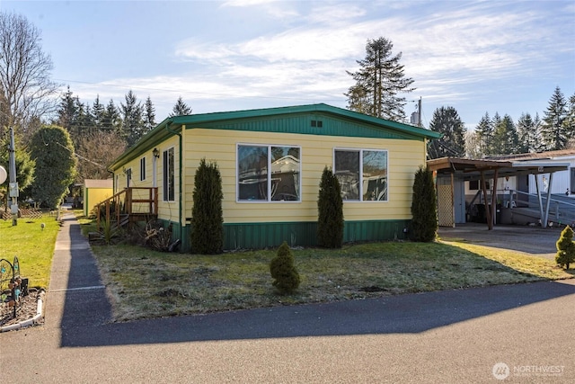 view of side of property with a lawn and a carport