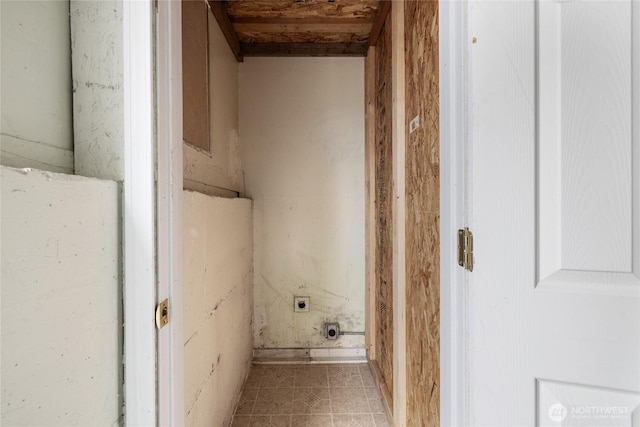 laundry area with electric dryer hookup and light tile patterned floors