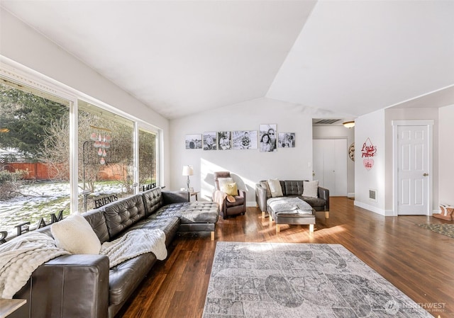 living area with vaulted ceiling, wood finished floors, and visible vents